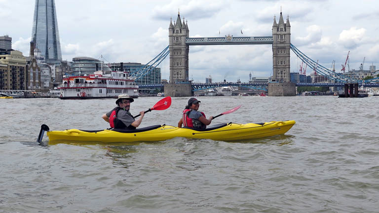 Kayaking by Tower Bridge on the River Thames in London with London 